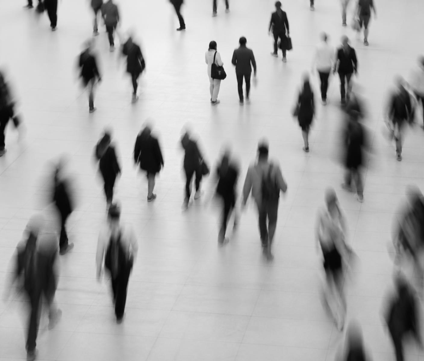 People moving through an open space, photographed in monochrome